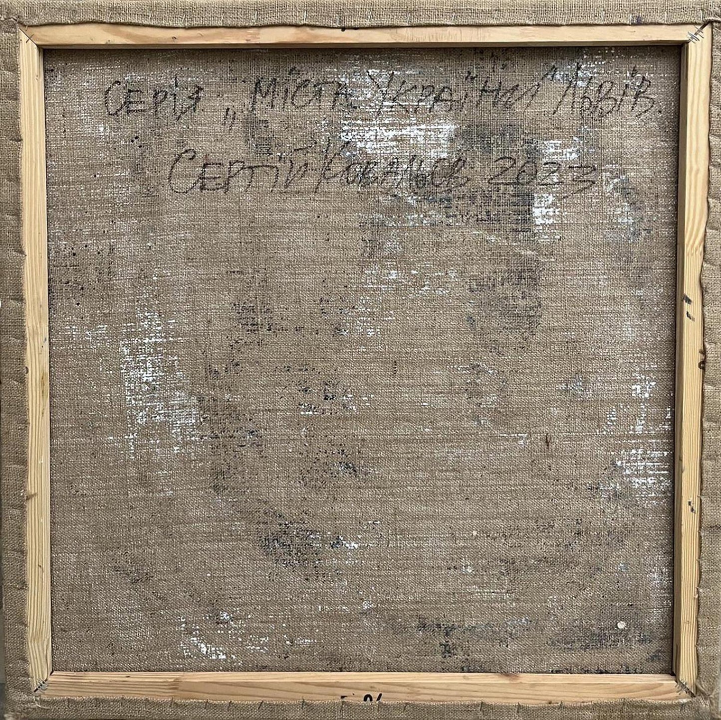 Back of Serhiy Kovalev oil painting City center framed canvas with Cyrillic text on beige linen