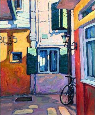 Black TEST TEST TEST bicycle leaning against vibrant red wall in colorful alley