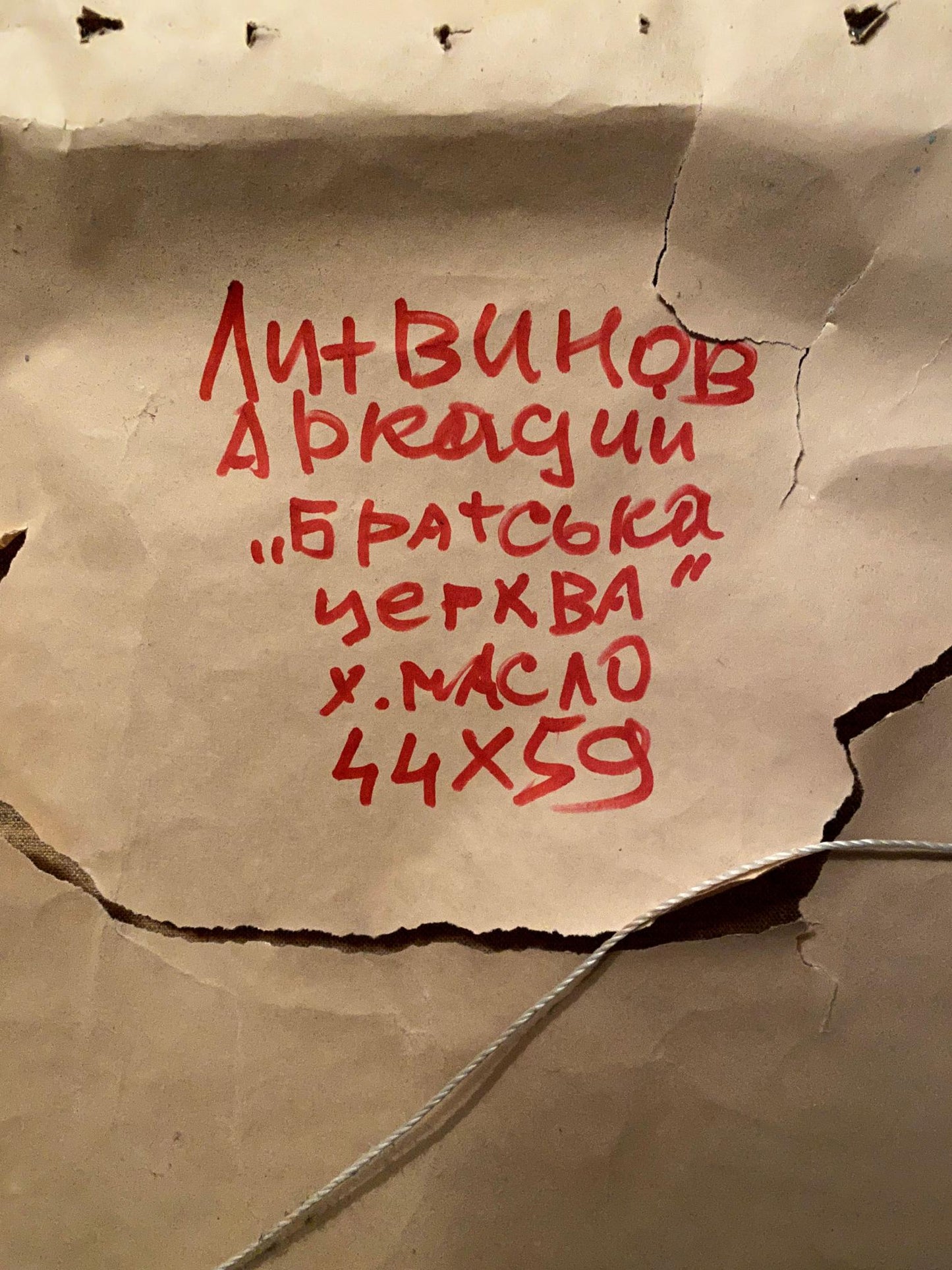 Back of torn beige paper with red Cyrillic text, Oil painting Fraternal church Litvinov Arkady Petrovich