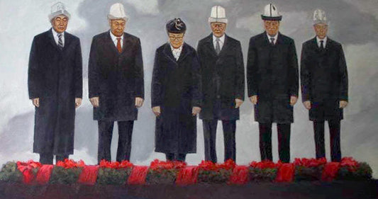 Six men in dark coats and white hard hats before red floral tributes