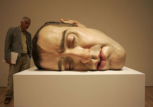 Hyperrealistic sculpture of sleeping human head in art exhibit
