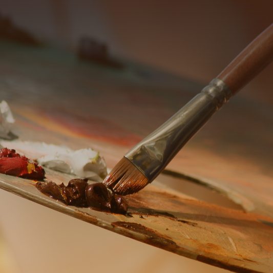 Paintbrush with wooden handle, metal ferrule, and brown paint bristles