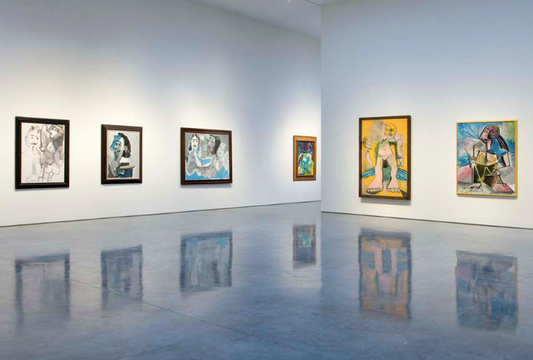 Framed oil paintings on white walls in modern art gallery