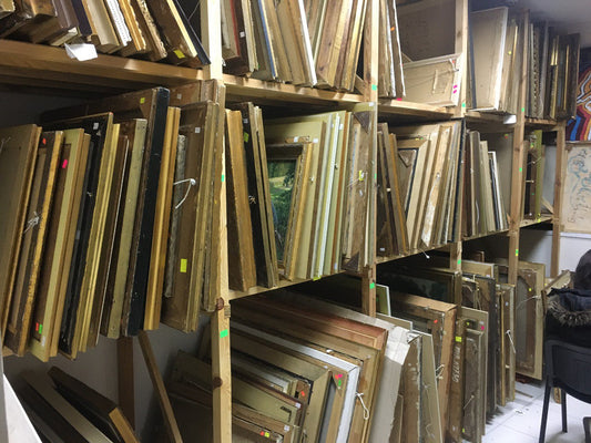 Stacks of vintage wooden picture frames in gold, black, natural tones