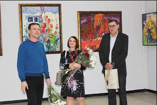 Woman in black floral dress holding bouquets at Lubny Gallery Pyriatyn exhibition