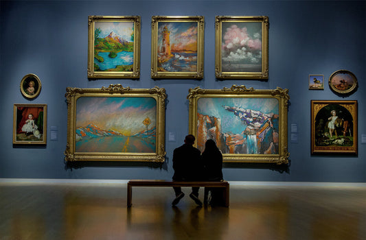Golden-framed paintings on blue gallery wall for art collection updates