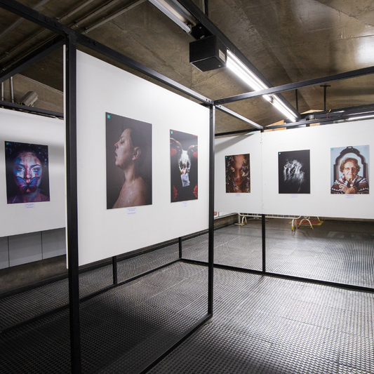 Black-framed gallery walls of high-contrast portrait photos in art restoration