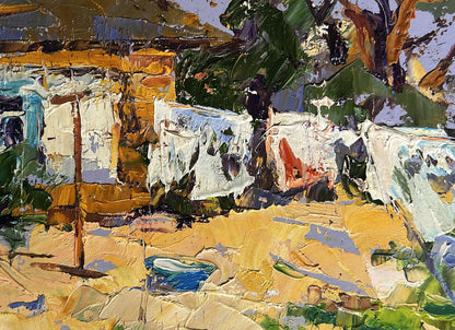 Vibrant oil painting by Oleksiy Ivanyuk: sunlit village with clothes drying