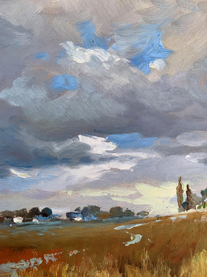Oil painting Not far from the village by Yuriy Suprunchuk, dramatic sky over golden field