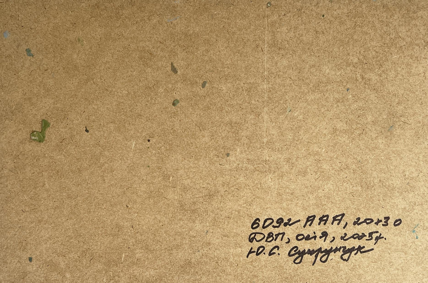 Back of Yuriy Suprunchuk oil painting River in the mountains with handwritten ink note on brown cardboard