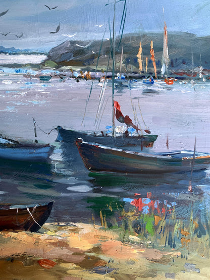 Oil painting by Yuriy Suprunchuk: dark wooden sailboat with red flag, blue sails moored near rocky shore
