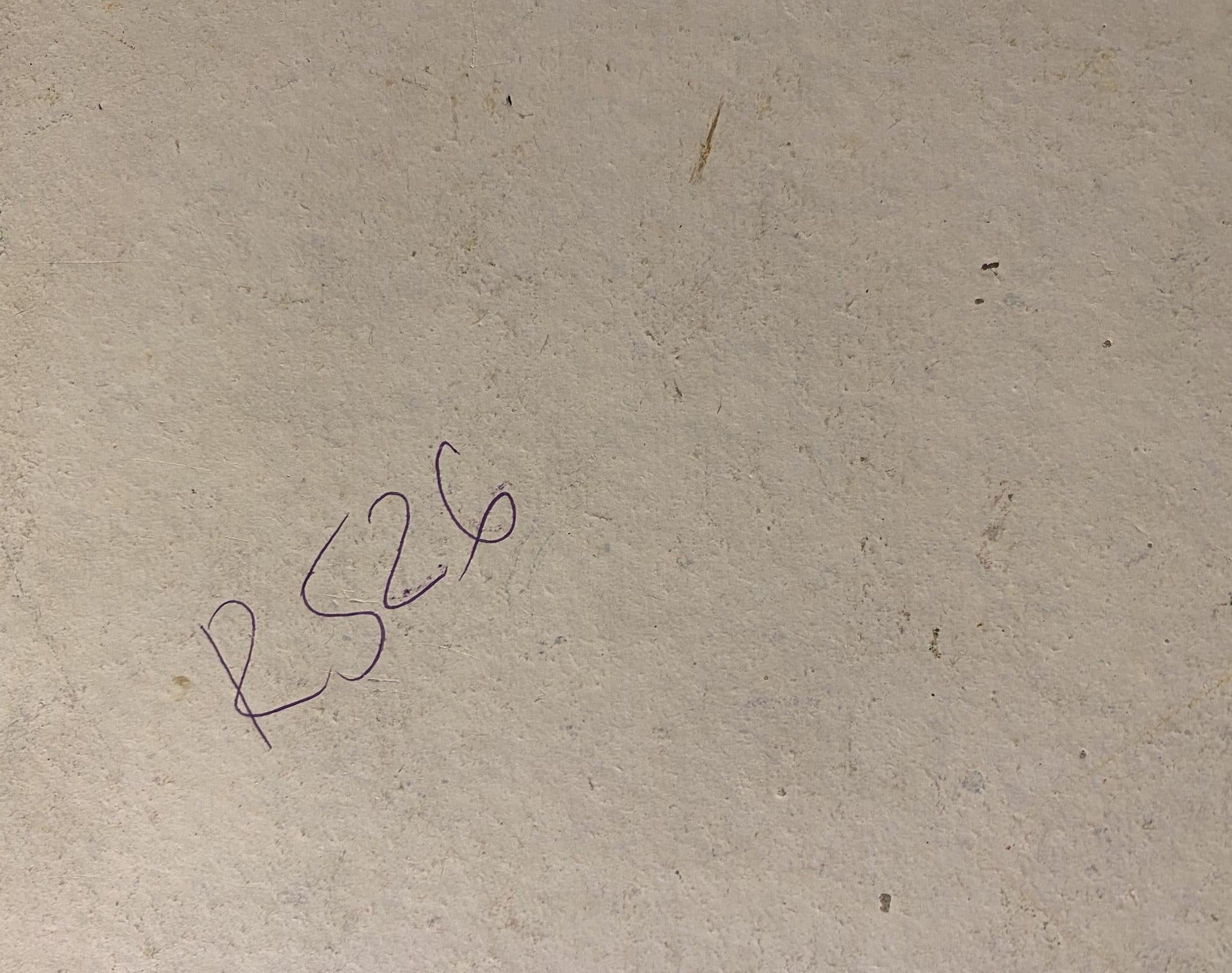 Back of Georgy Kolosovsky oil painting with handwritten rs26 on beige surface