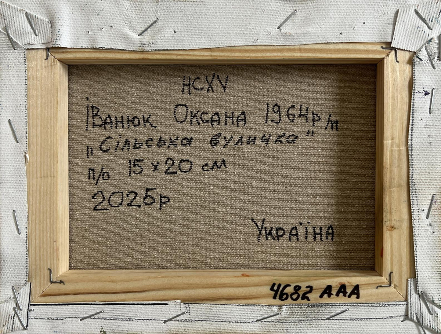 Back of Oil painting Warm rural street Oksana Ivanyuk in light brown wooden frame with textured fabric and Cyrillic text