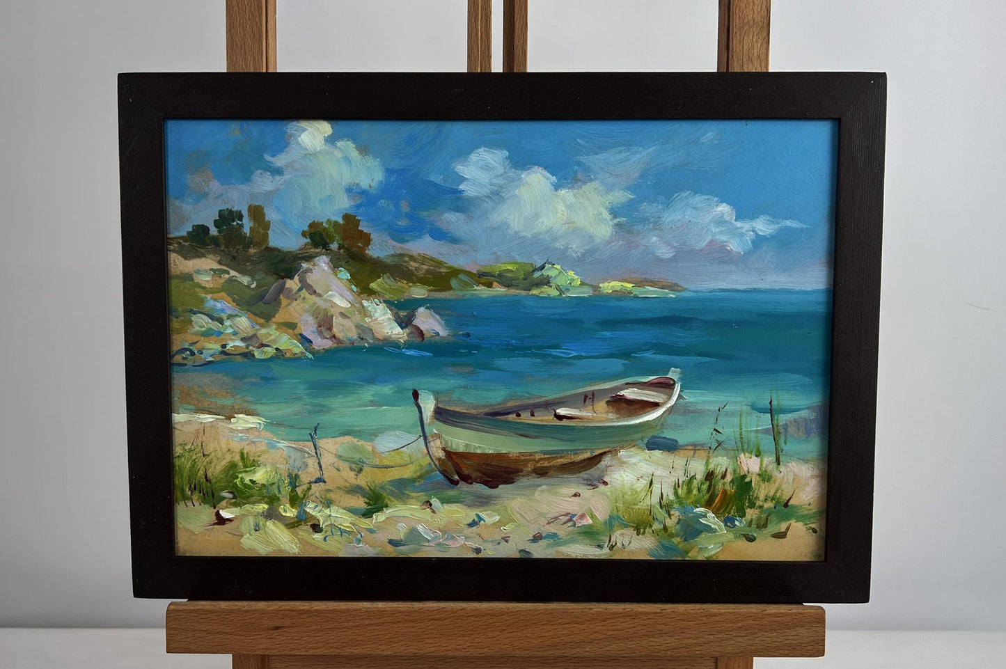 Oil painting of white brown boat on seashore by Yuriy Suprunchuk in dark frame