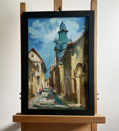Oil painting by Yuriy Suprunchuk: sunlit European street with teal-domed tower
