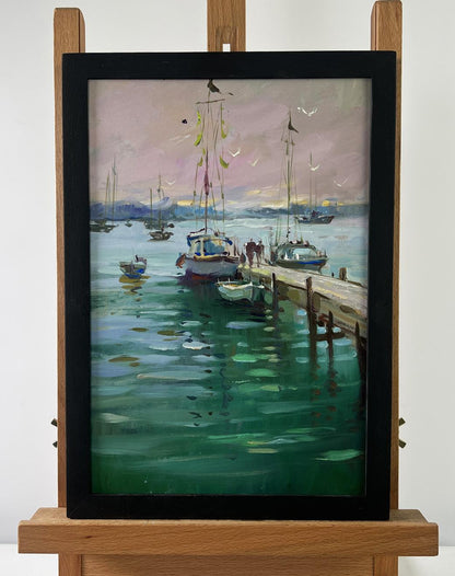 Oil painting Where boats sleep at the pier by Yuriy Suprunchuk in black frame on easel