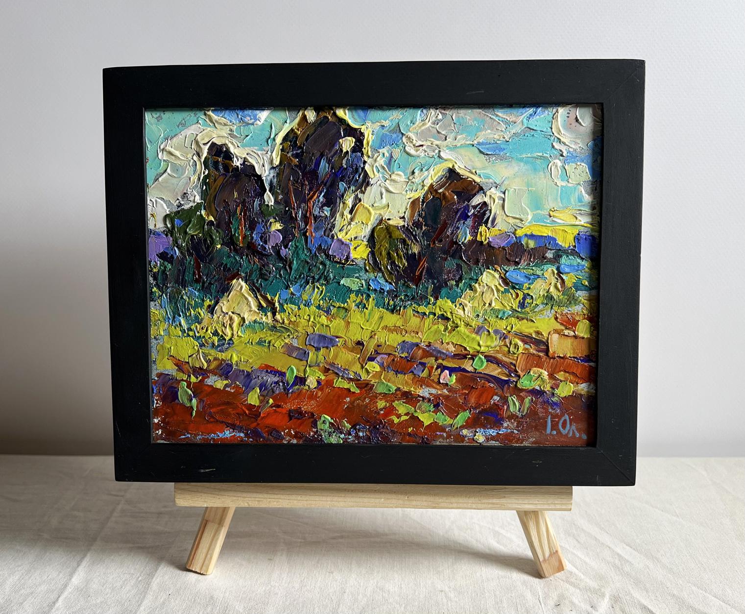 Oil painting of plowed field and haystacks by Oleksiy Ivanyuk in black frame