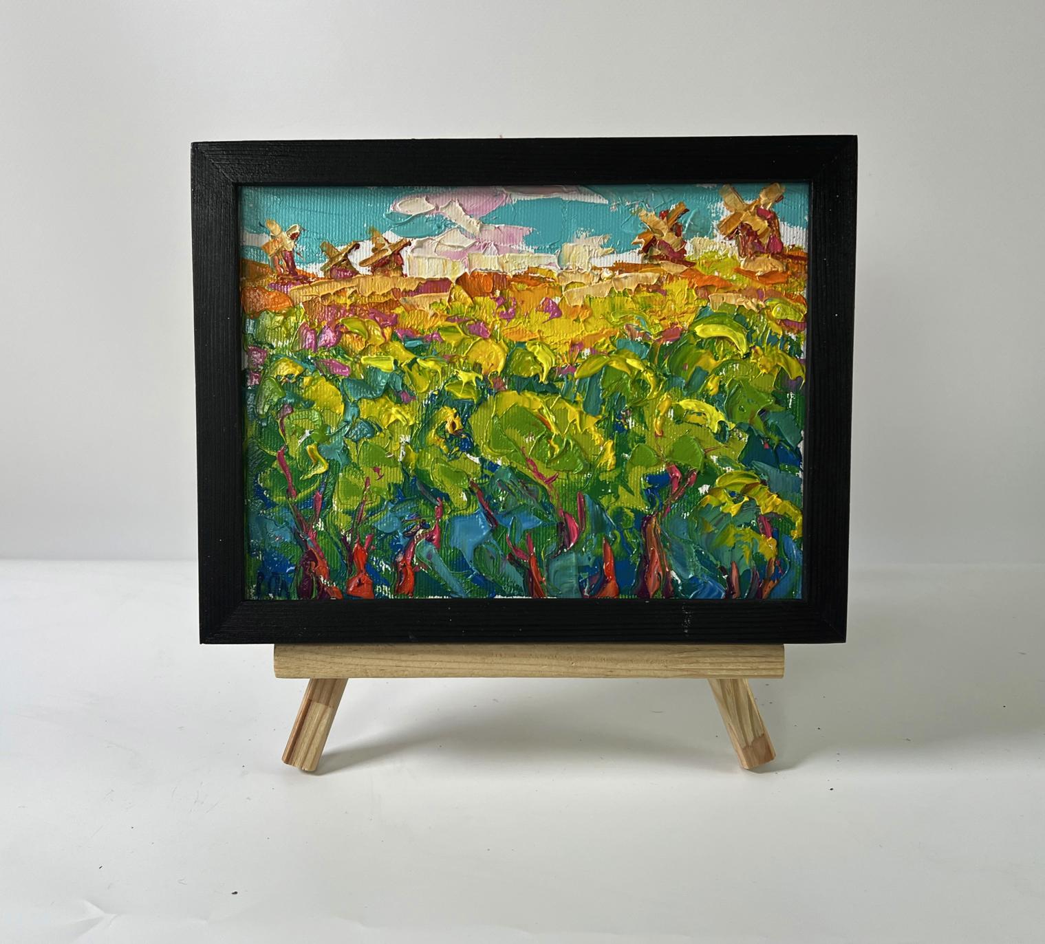 Vibrant Oleksiy Ivanyuk oil painting of sunlit summer forest fields with windmills on easel