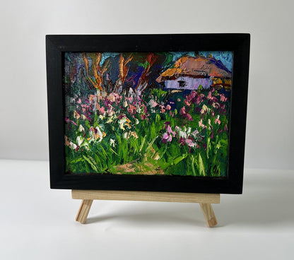 Oil painting by Oleksiy Ivanyuk: irises field with thatched cottage on easel
