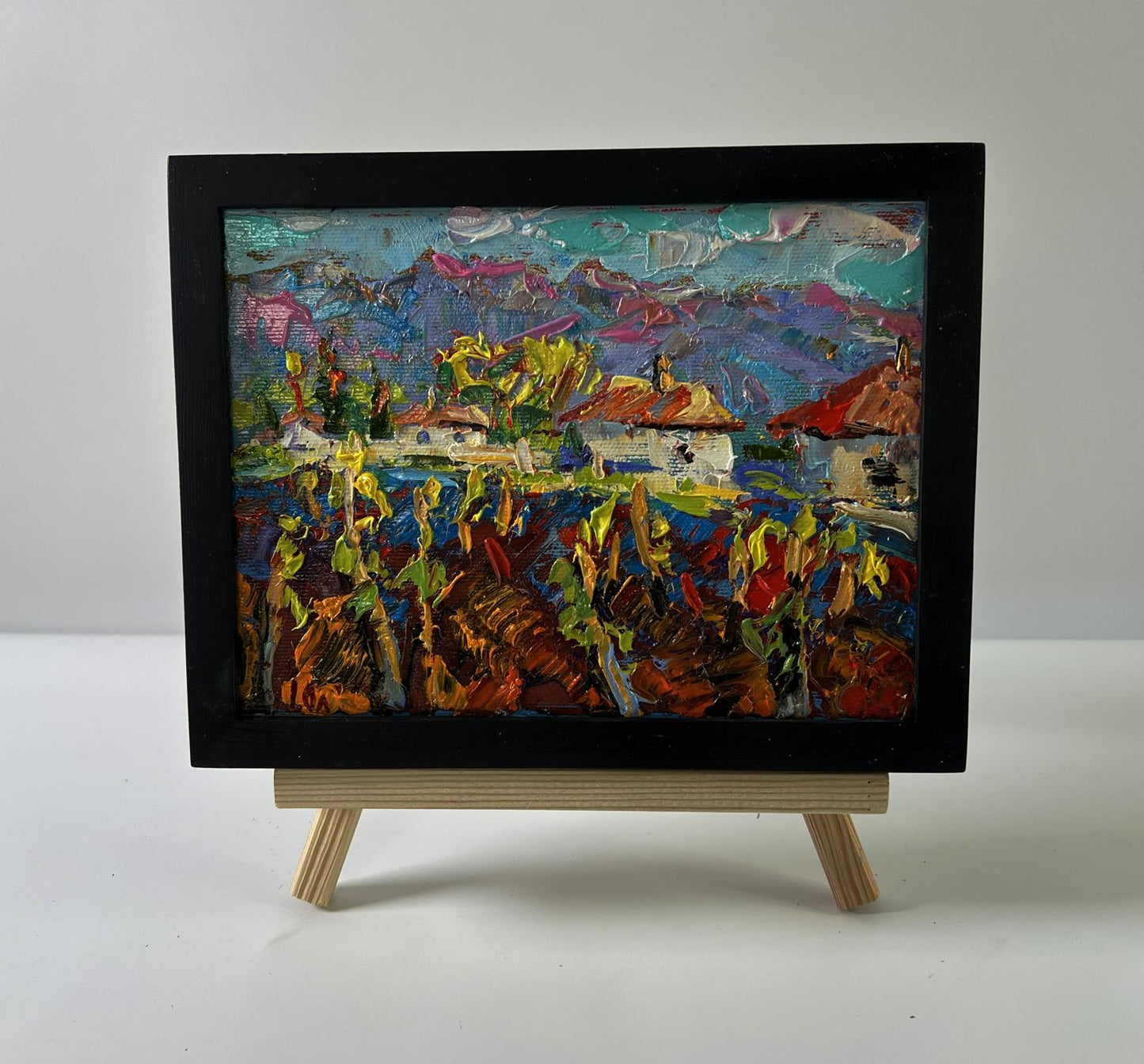 Vibrant textured oil painting of Oleksiy Ivanyuk Clean village air in black frame on easel