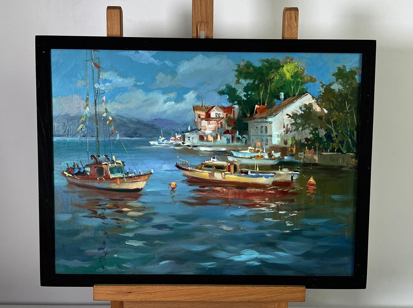 Oil painting of river ships near shore by Yuriy Suprunchuk in black frame