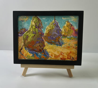 Oil painting of colorful haystacks in field by Oleksiy Ivanyuk in black frame