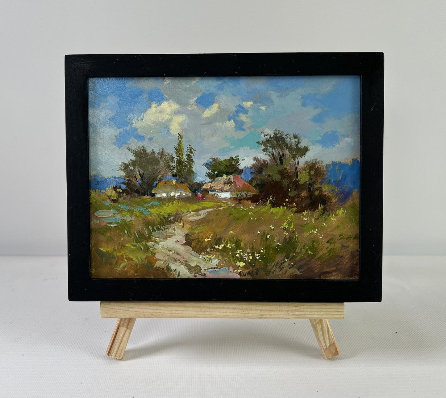 Black-framed miniature oil painting of village on hill by Yuriy Suprunchuk