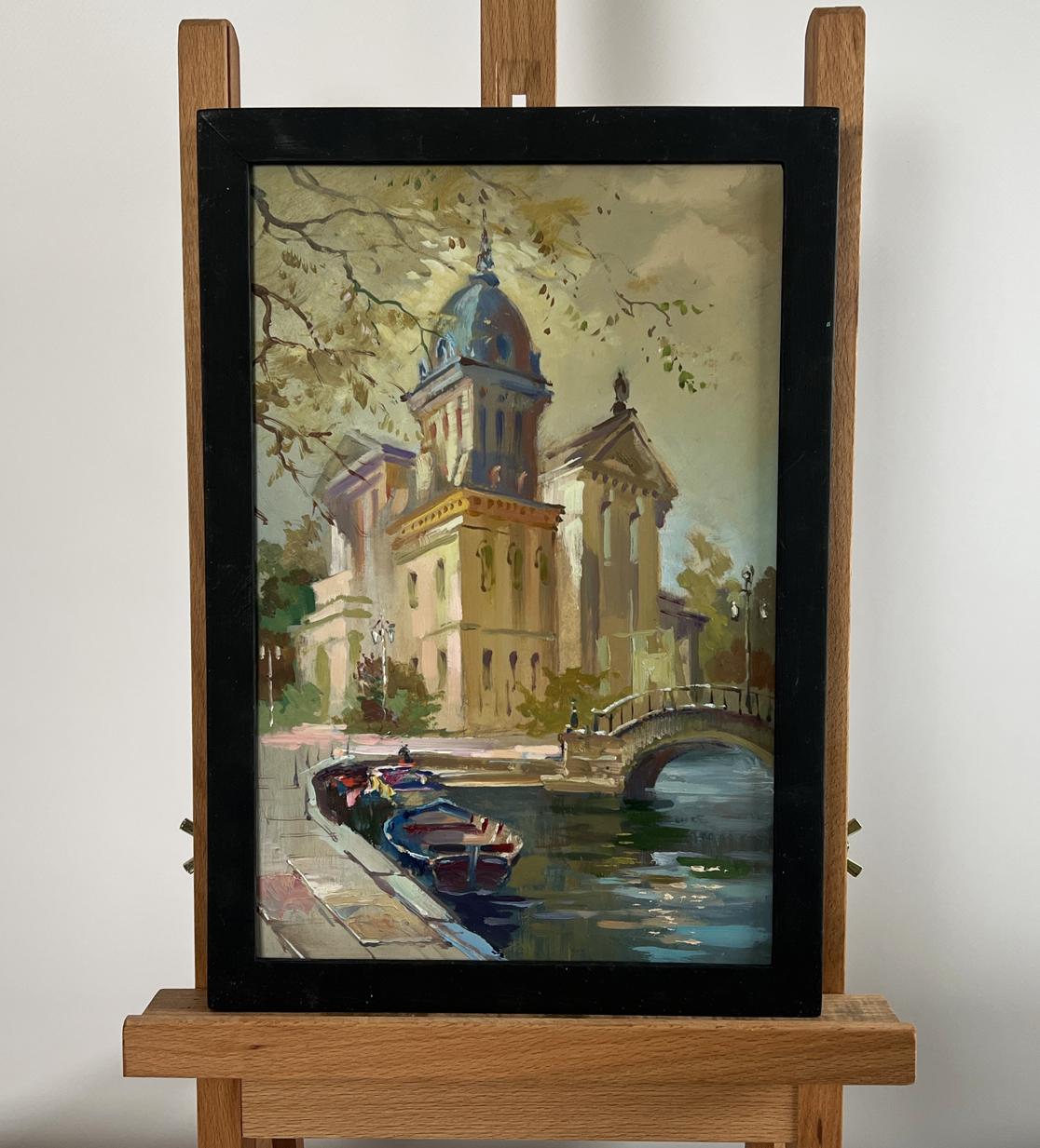 Framed oil painting of Yuriy Suprunchuk river cityscape with blue dome canal on easel