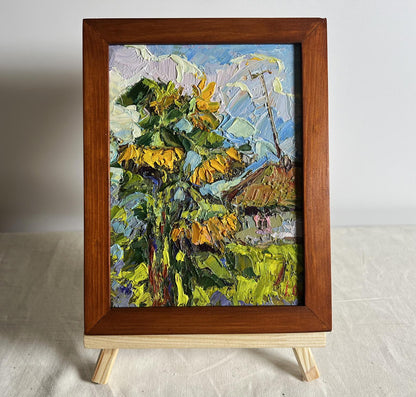 Vibrant oil painting of sunflowers near the house by Oksana Ivanyuk in rustic frame