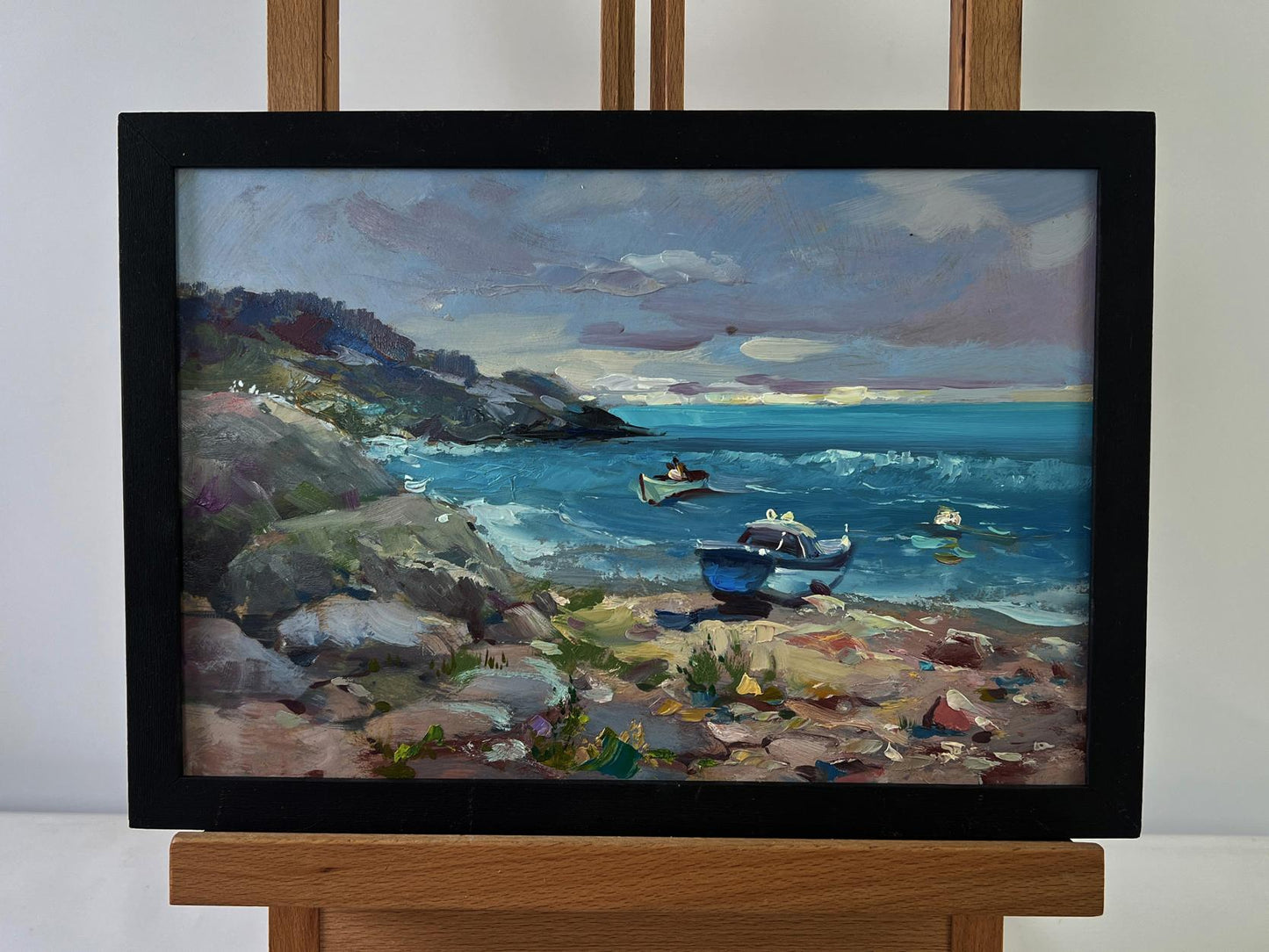 Oil painting by Yuriy Suprunchuk: sea waves crashing on rocky shores in black frame