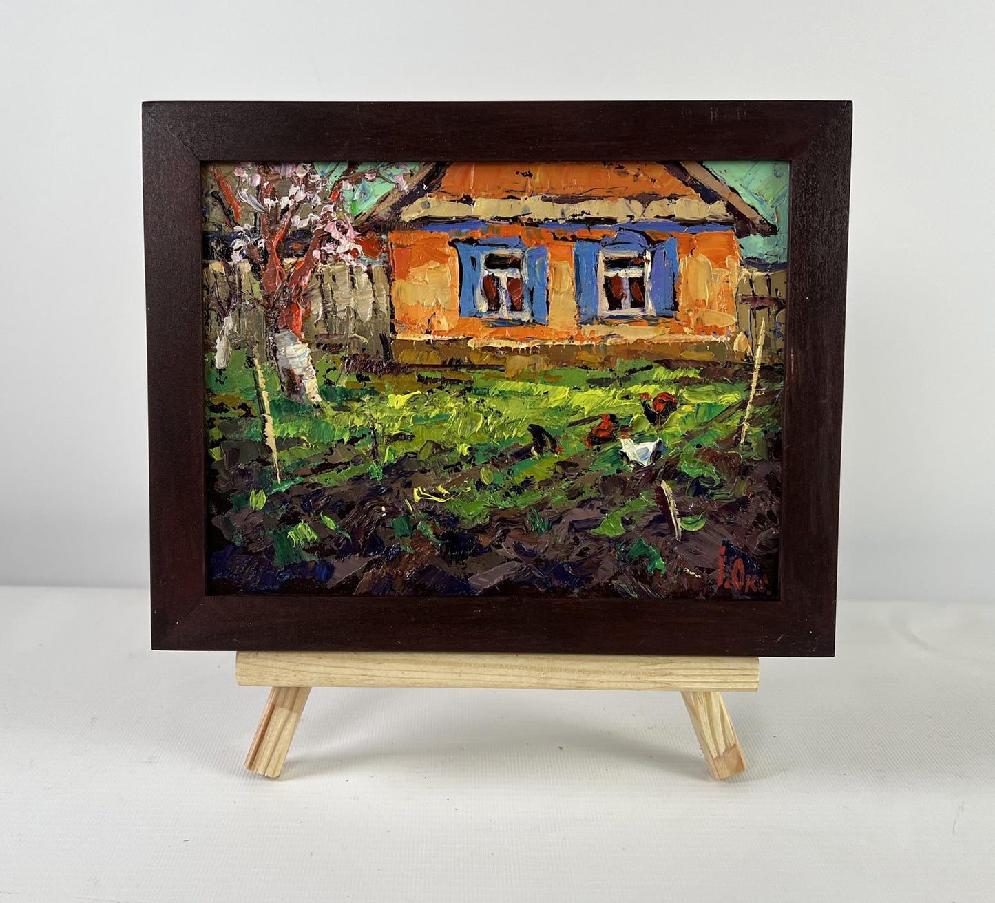 Rustic oil painting by Oksana Ivanyuk: orange house, blue shutters, chickens in grass