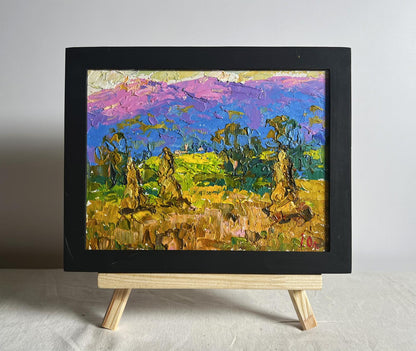 Oil painting of haystack and mountains by Oleksiy Ivanyuk in black frame