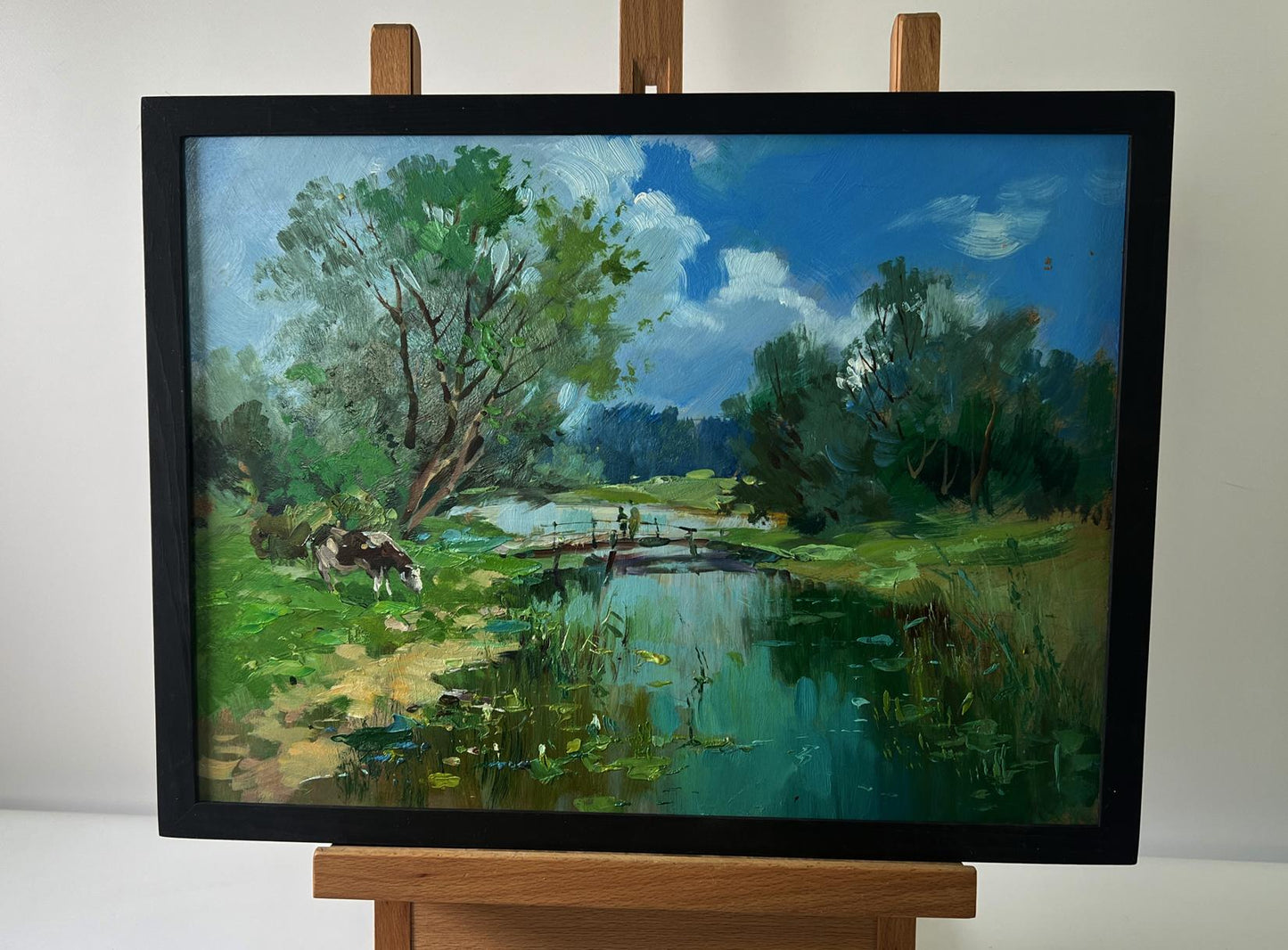 Framed oil painting by Yuriy Suprunchuk: bridge over serene river with cows