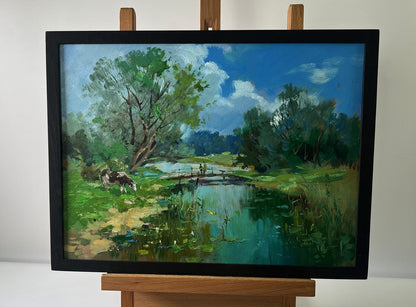 Framed oil painting by Yuriy Suprunchuk: bridge over serene river with cows