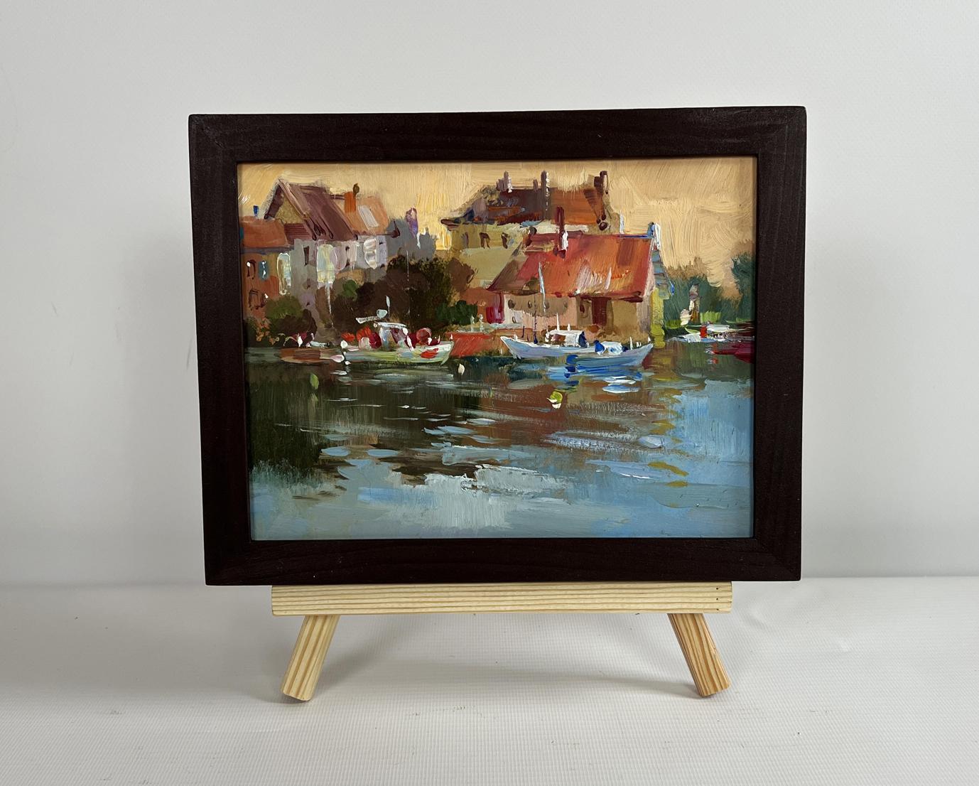 Framed oil painting of sunset glow over harbor rooftops by Yuriy Suprunchuk