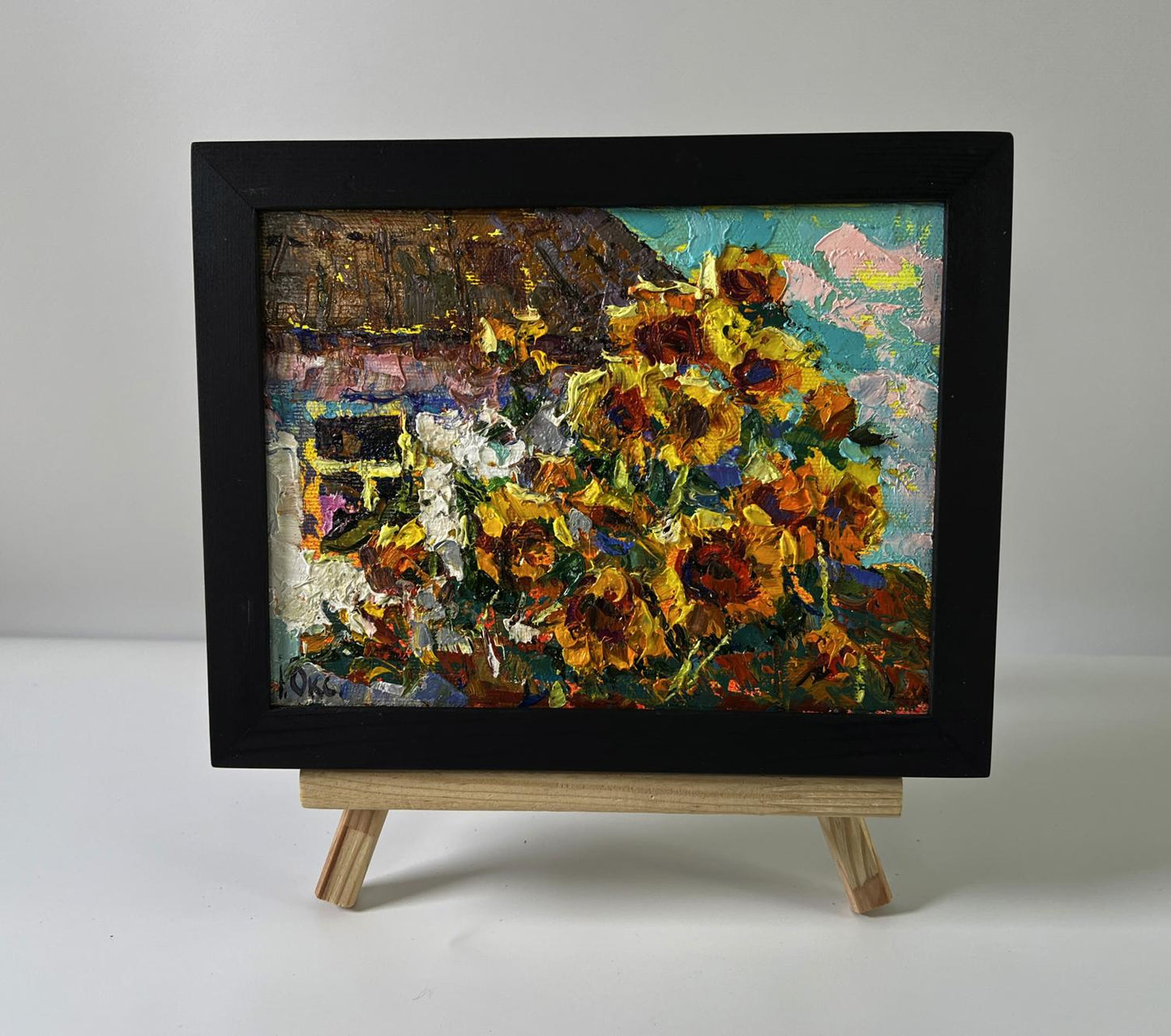 Vibrant oil painting of sunflowers in black frame by Oksana Ivanyuk