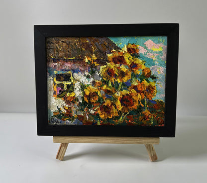 Vibrant oil painting of sunflowers in black frame by Oksana Ivanyuk