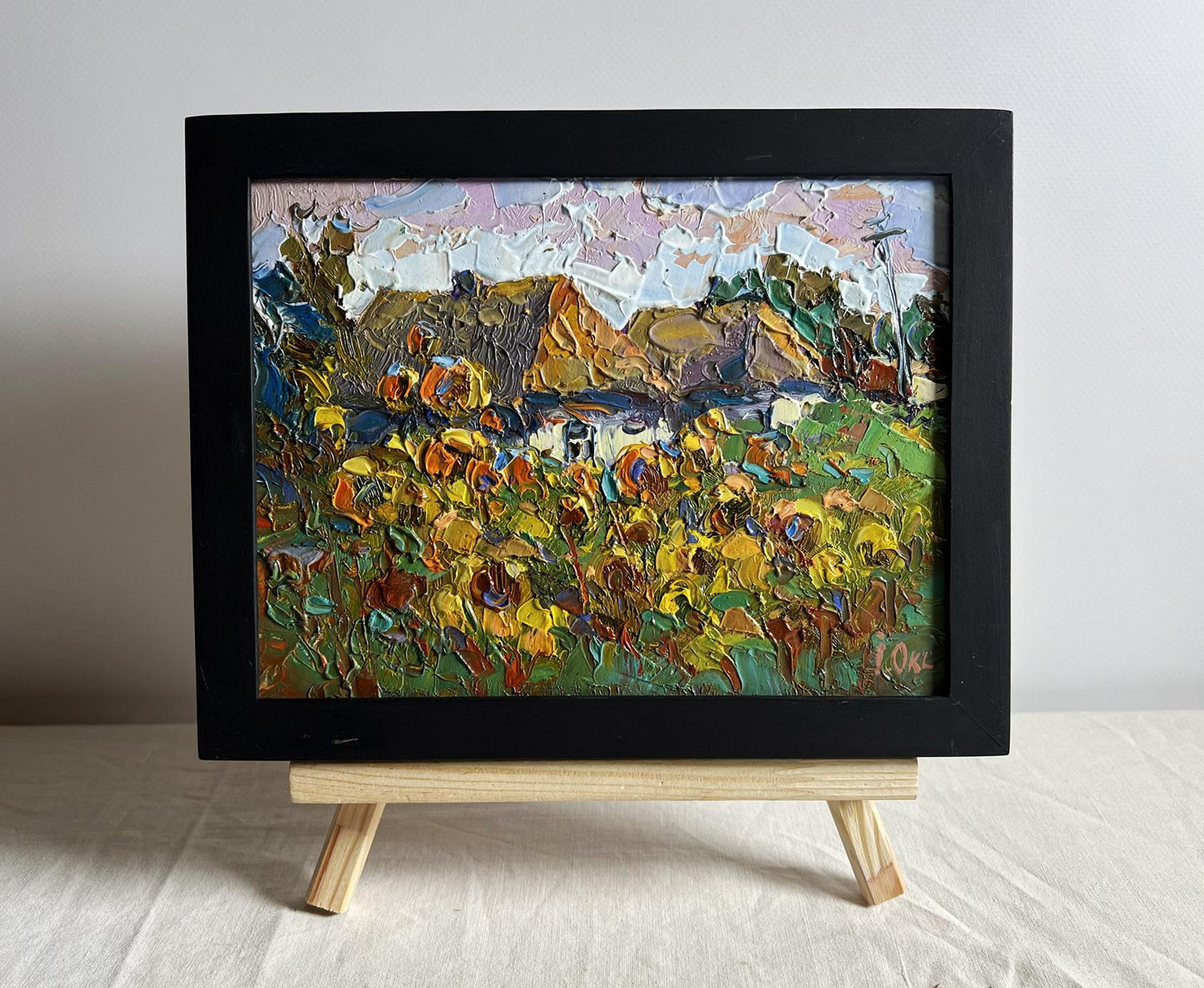 Oil painting of sunflower field and cozy village by Oksana Ivanyuk