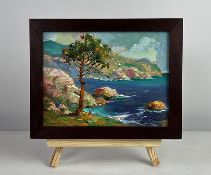 Framed oil painting of coastal landscape with tree by Yuriy Suprunchuk on easel