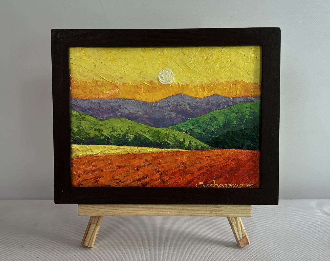 Oil painting of layered mountains in evening sun by V. Zadorozhnya, framed on easel