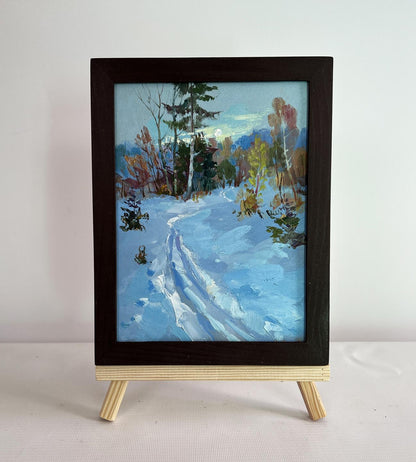 Oil painting Winter sunset in the forest by Yuriy Suprunchuk in dark frame on easel