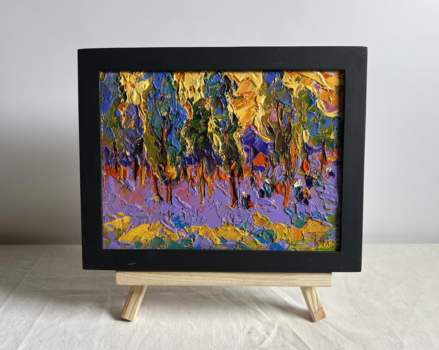 Oil painting of yellow sunset behind trees by Oleksiy Ivanyuk in black frame