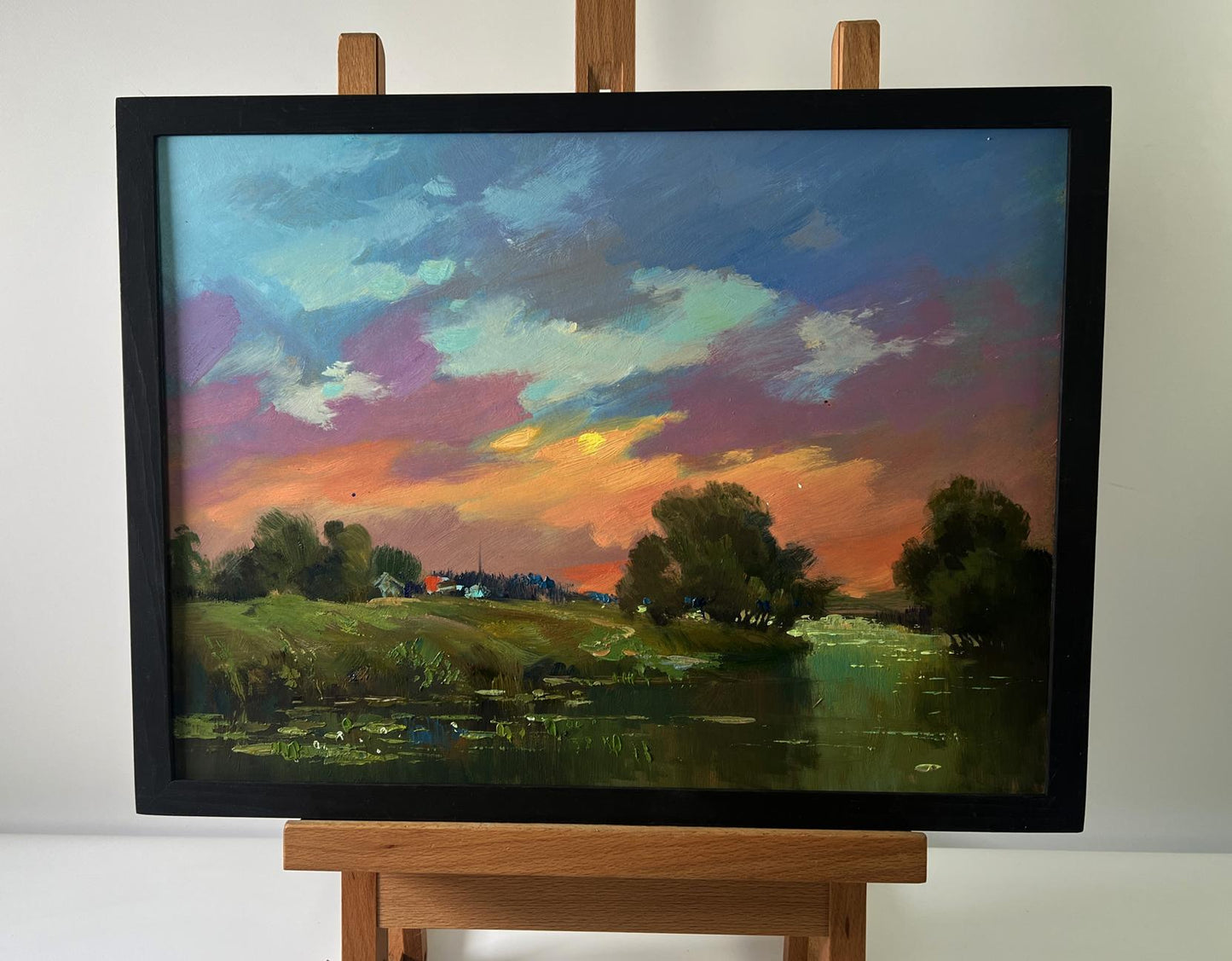 Oil painting of orange sunset over river by Yuriy Suprunchuk in black frame