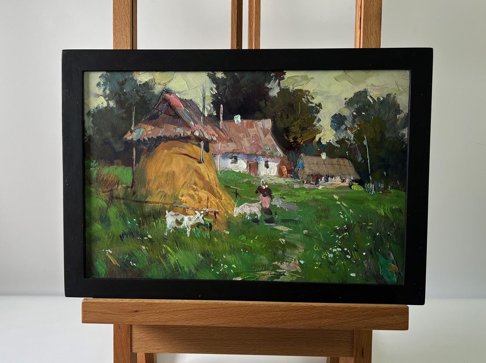 Rustic oil painting by Yuriy Suprunchuk of countryside hay bales and cottages in black frame