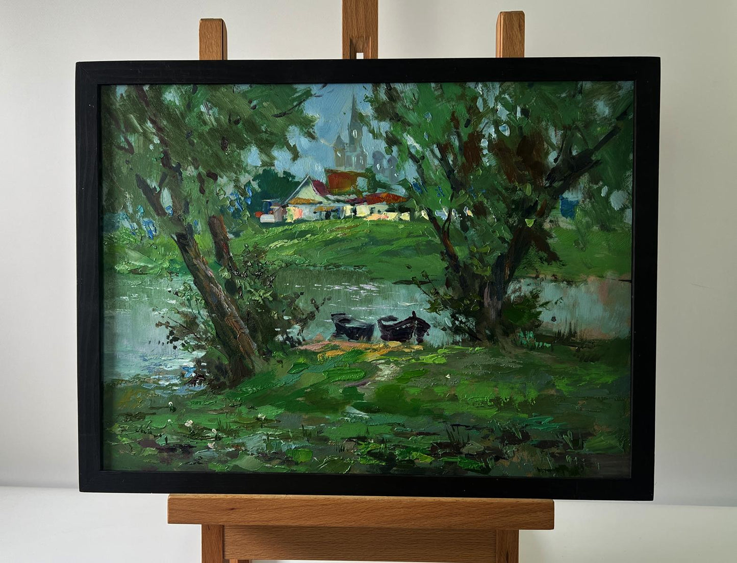 Framed oil painting of village river with two boats by Yuriy Suprunchuk
