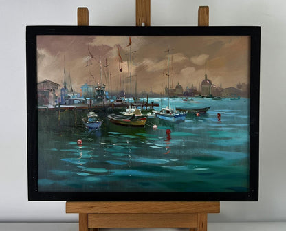 Oil painting Sunset at the city pier by Yuriy Suprunchuk in black frame on easel