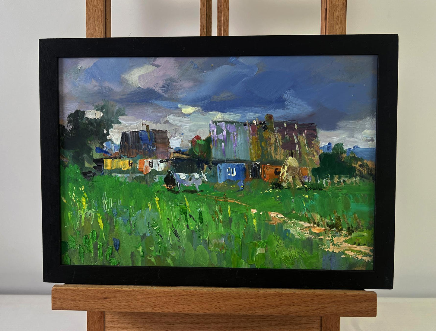 Framed impressionist oil painting of rural idyll with huts, cattle by Yuriy Suprunchuk