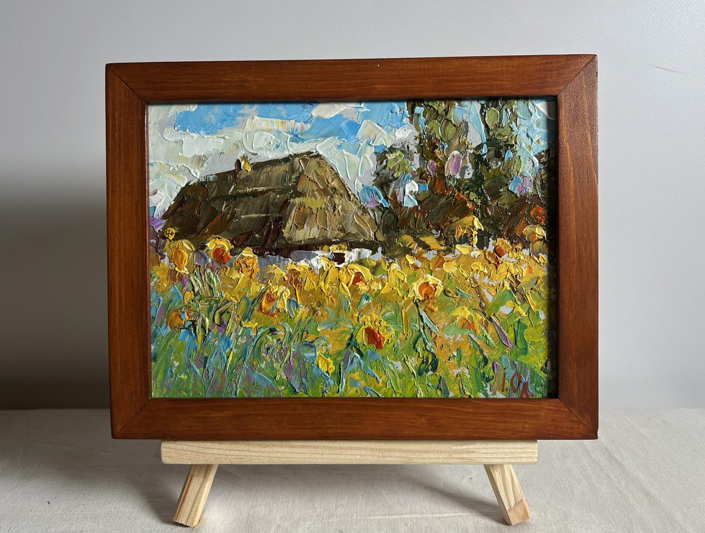 Oil painting of thatched cottage and sunflowers by Oleksiy Ivanyuk