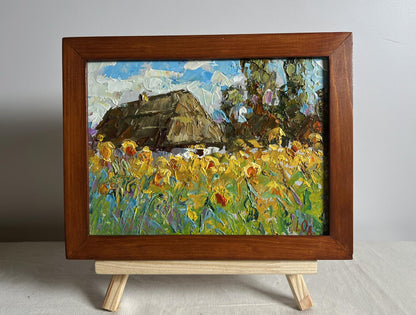 Oil painting of thatched cottage and sunflowers by Oleksiy Ivanyuk