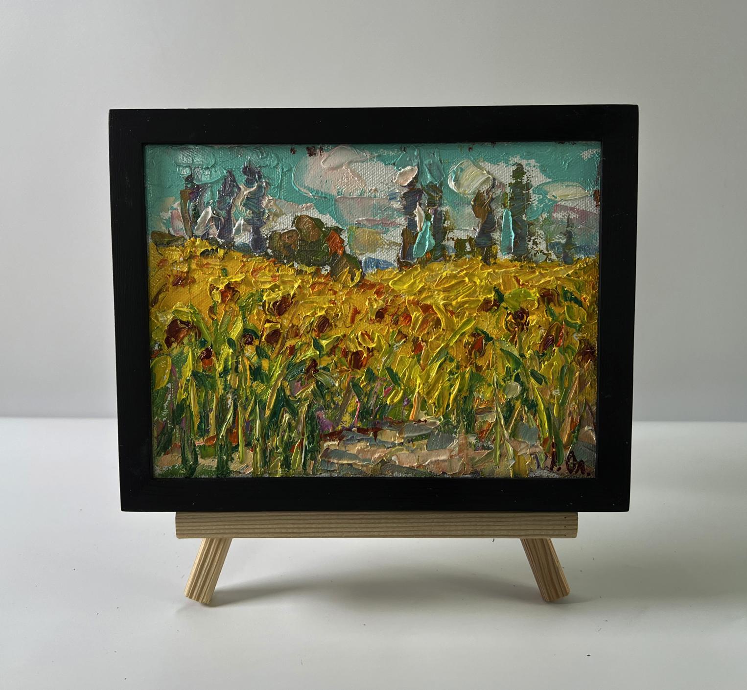 Oil painting of sunflower field by Oleksiy Ivanyuk in black frame on easel